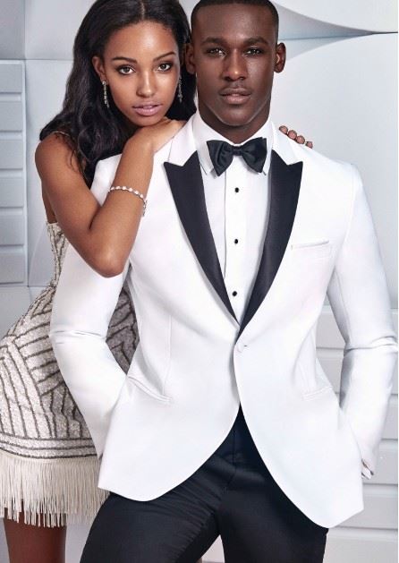 Male and female model wearing evening attire. Female wearing a short white dress and male wearing a