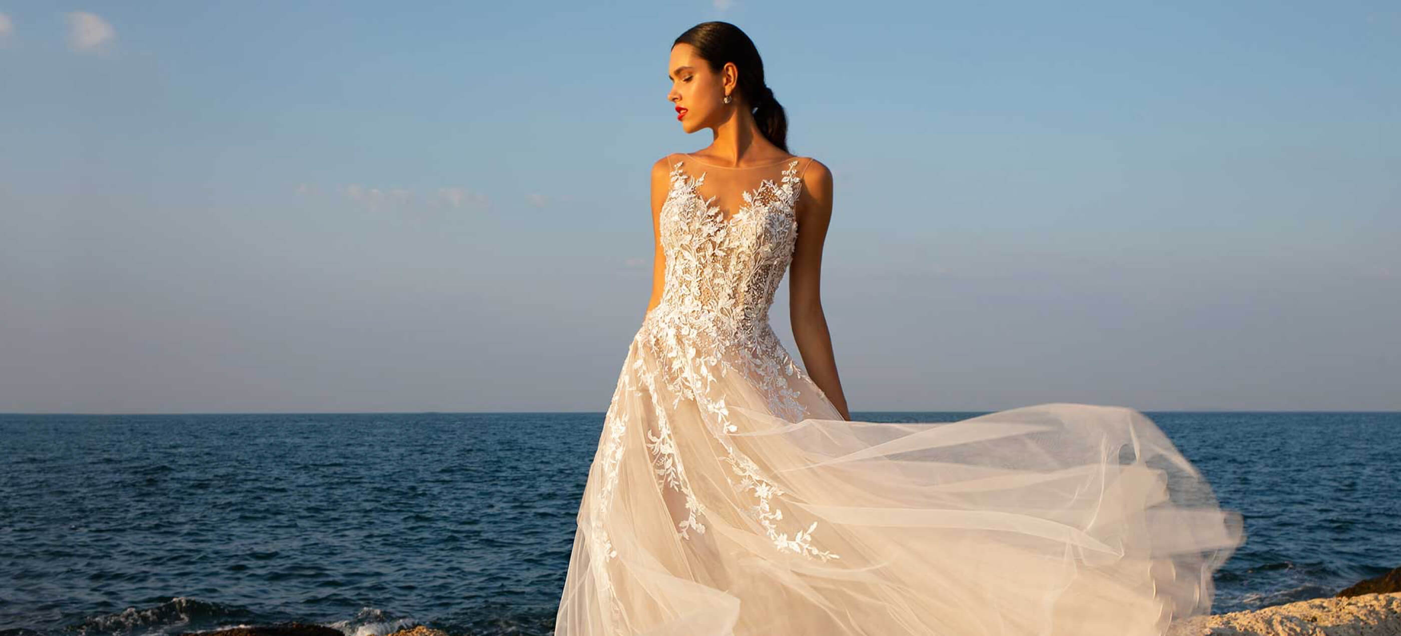 Model wearing a white wedding dress with floral details from Ana's Bridal in East Providence Rhode Island